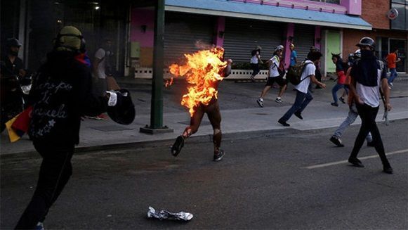 Un hombre al que prendieron fuego camina envuelto en llamas en Venezuela, durante las protestas de la oposición contra el presidente del país, Nicolas Maduro, el 20 de mayo de 2017. Foto: Marco Bello/ Reuters.