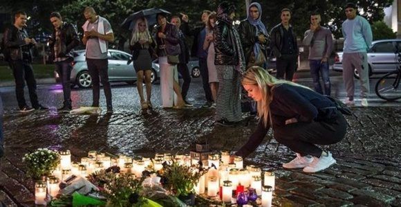 Gente coloca velas en el lugar del ataque.Foto: EFE